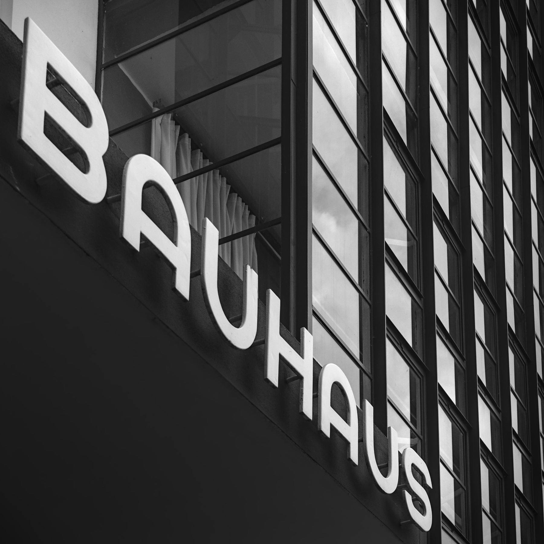 Foto vom Schriftzug Bauhaus über dem Haupteingang des Bauhaus in Dessau-Roßlau in schwarz-weiß